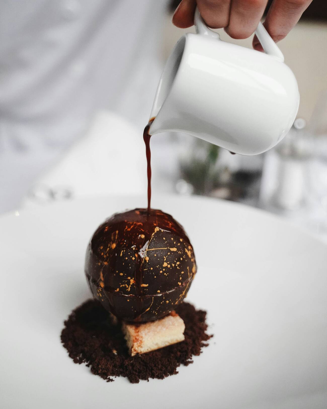 Dessert wird am Tisch mit Sauce vollendet