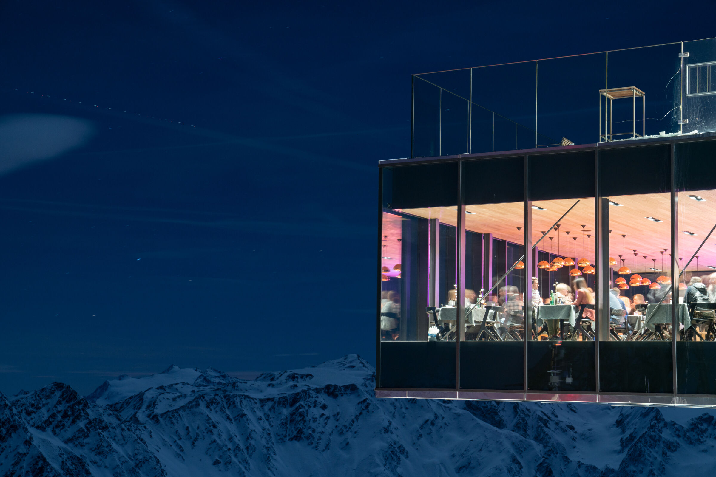 Das beleuchtete ice Q am Abend über den verschneiten Ötztaler Alpen